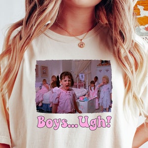 May include: A white t-shirt with a graphic print of a scene from the movie "The Parent Trap". The graphic shows a group of girls in pink dresses, with one girl sticking her tongue out and saying "Boys... Ugh!"