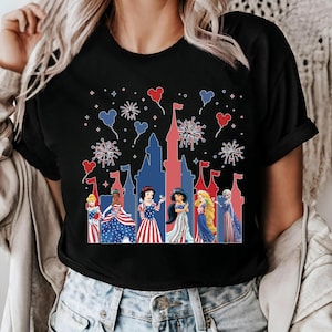 K&ouml;nnte beinhalten: Schwarzes T-Shirt mit einem patriotischen Schlossdesign, Feuerwerk und herzf&ouml;rmigen Ballons. Das Shirt zeigt Prinzessinnen in rot, wei&szlig; und blauer Kleidung, ideal f&uuml;r eine Themenfeier.