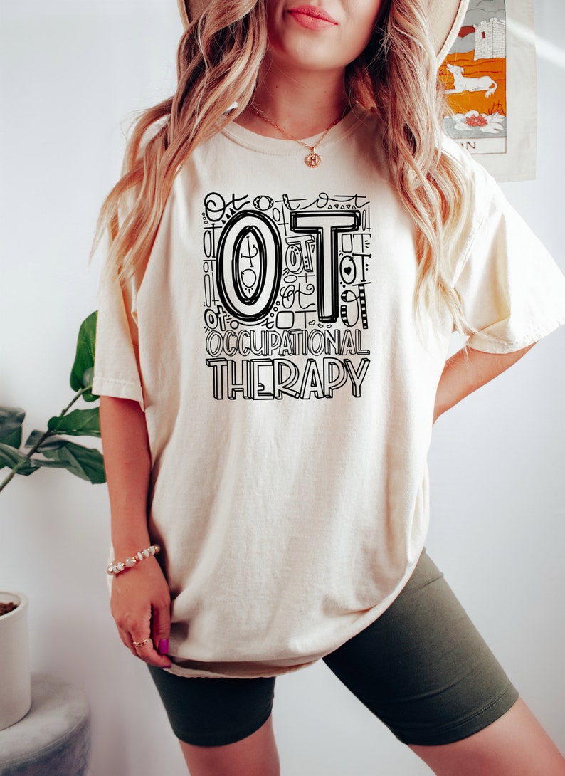 May include: A white t-shirt with a black graphic design that says "OT Occupational Therapy" with the letters "OT" repeated in a stylized design.