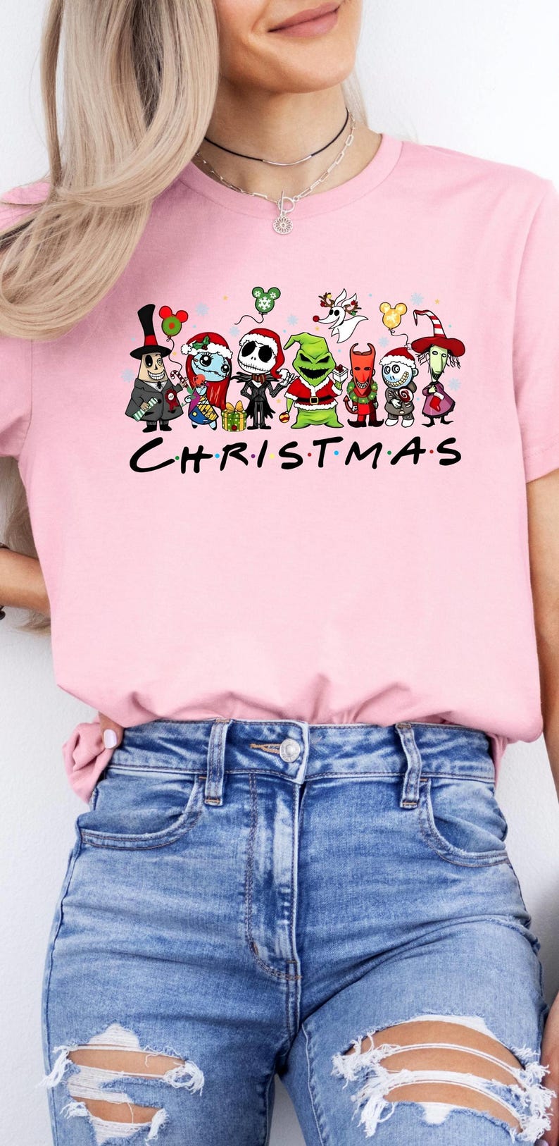 May include: Pink t-shirt with a graphic of cartoon characters from The Nightmare Before Christmas and the text "CHRISTMAS".