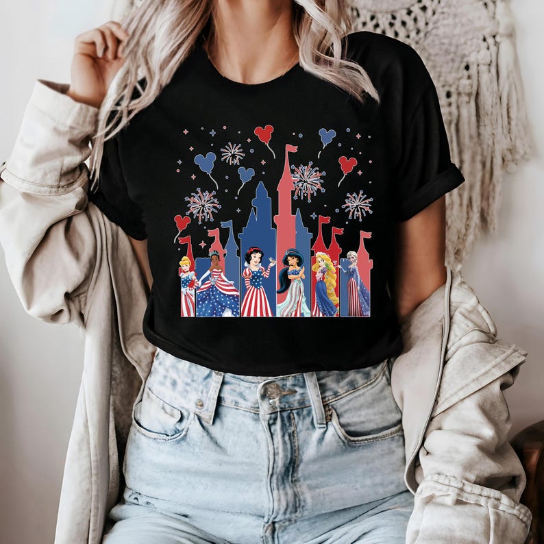 K&ouml;nnte beinhalten: Schwarzes T-Shirt mit einem patriotischen Schlossdesign, Feuerwerk und herzf&ouml;rmigen Ballons. Das Shirt zeigt Prinzessinnen in rot, wei&szlig; und blauer Kleidung, ideal f&uuml;r eine Themenfeier.