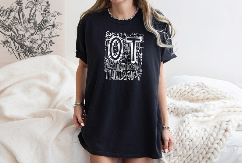 May include: A black t-shirt with a white graphic design that says "OT Occupational Therapy" with the letters "OT" in a larger font size.