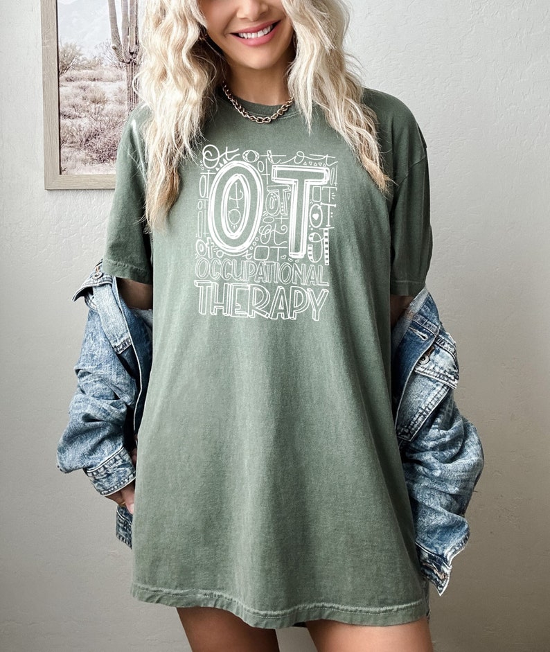 May include: A green t-shirt with a white graphic design that says "OT Occupational Therapy". The graphic design is made up of the letters "OT" surrounded by smaller versions of the letters "OT" and other symbols.