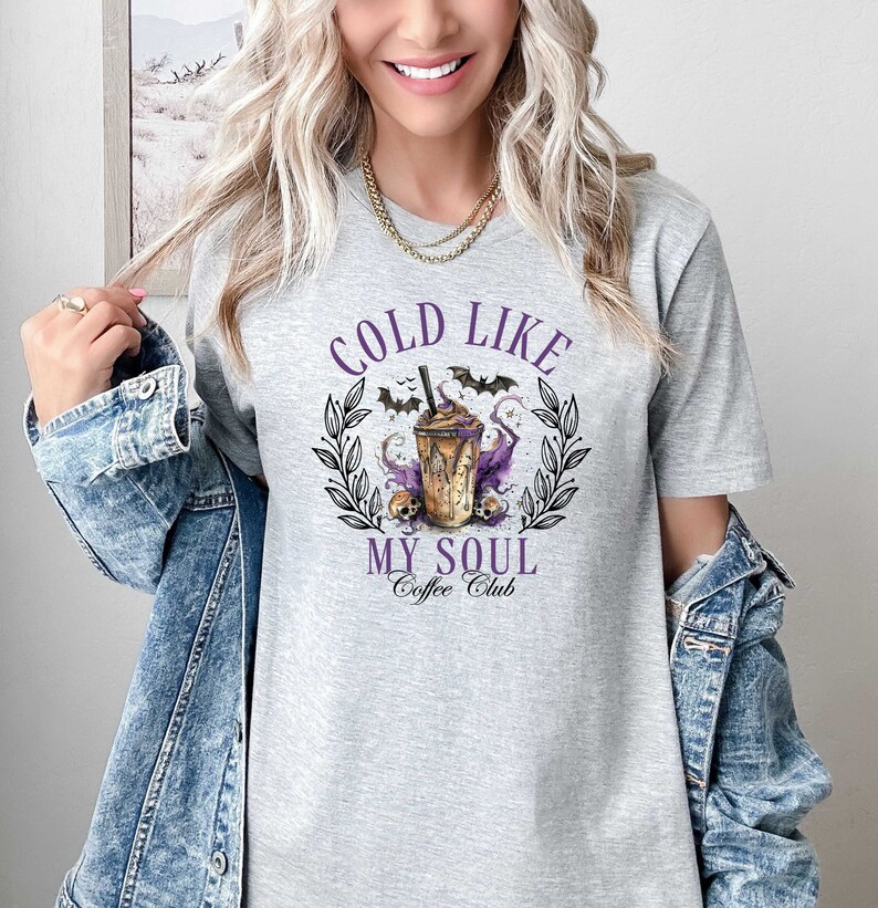 May include: Gray t-shirt with a graphic of a coffee drink with bats and skulls. The text reads "Cold Like My Soul Coffee Club".
