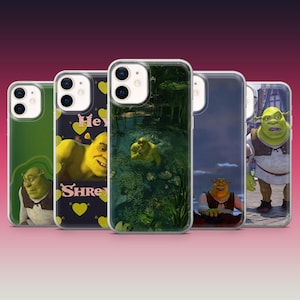 May include: Five different phone cases featuring Shrek characters. The cases are clear and show different images of Shrek, including Shrek in a swamp, Shrek with a heart, and Shrek with a crown. The cases are all for iPhones.