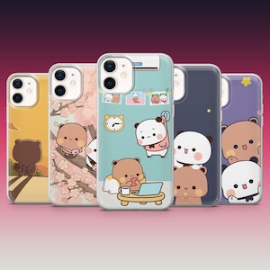 May include: A collection of phone cases featuring cute cartoon bear and panda designs. The cases showcase various scenes, including bears with cherry blossoms, working on a laptop, and other playful illustrations. The cases have a clear, glossy finish.