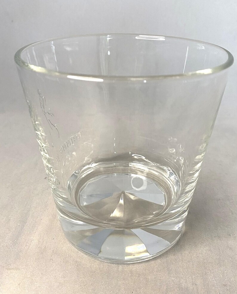Puede incluir: Un vaso de vidrio transparente y vac&iacute;o con una base facetada y un borde ligeramente ensanchado. El vaso tiene un dise&ntilde;o grabado en el lateral. El vaso est&aacute; dise&ntilde;ado para beber bebidas.
