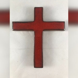 May include: A red ceramic cross with a slightly textured surface.