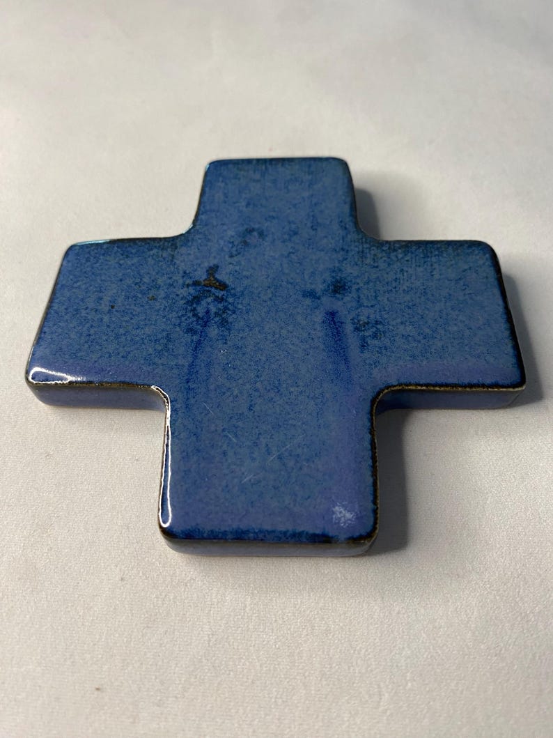 K&ouml;nnte beinhalten: Ein blaues Keramikkreuz mit leicht strukturierter Oberfl&auml;che.