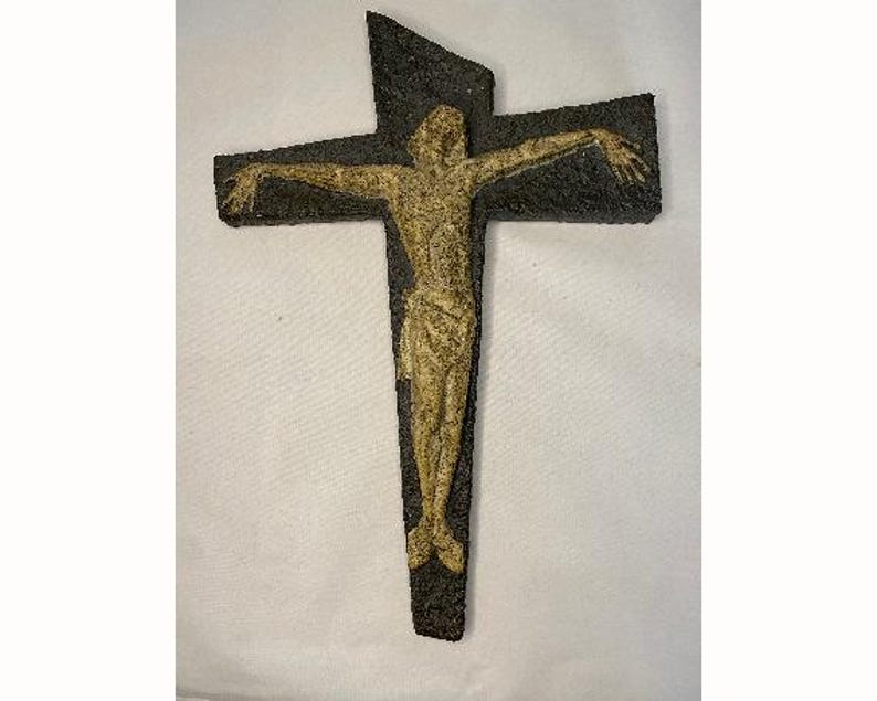 May include: A dark brown wooden crucifix with a raised, light brown figure of Jesus Christ.