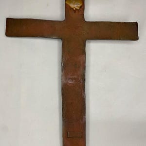 Może przedstawiać: Rustykalny, brązowy drewniany krzyż z postarzaną powierzchnią. Krzyż ma prosty design i idealnie nadaje się do dodania rustykalnego uroku każdemu domowi.