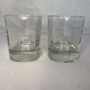 Puede incluir: Dos vasos transparentes de vidrio, perfectos para servir c&oacute;cteles o whisky. Los vasos est&aacute;n vac&iacute;os y tienen forma cuadrada.