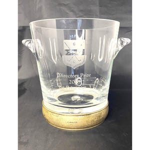 May include: A clear glass ice bucket with a silver base and engraved text that reads "Directors Prize 2018 1st Prize Golf", and a crest with the letters "M.G.D.C."