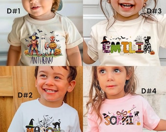 Peut inclure: Une collection de quatre t-shirts à manches courtes avec des motifs sur le thème d'Halloween. Les designs incluent des super-héros costumés, les noms ANTHONY, EMILIA, MASON et SOPHIA en lettres à motifs, des fantômes, des citrouilles, des chauves-souris et des chats noirs.