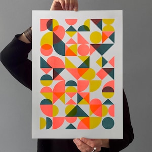 Peut inclure: Impression d'art géométrique abstrait avec un design coloré. L'œuvre présente une variété de formes, notamment des cercles, des triangles et des demi-cercles, en rose fluo, jaune, orange, sarcelle et marron sur fond blanc.