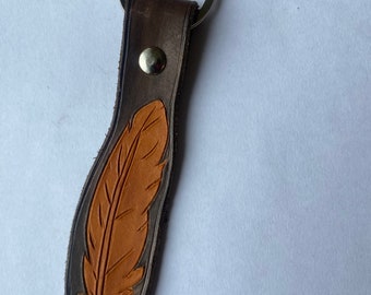 handmade leather keychain with carved feather design