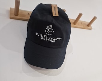 May include: Black baseball cap with a white horse logo and the text "WHITE HORSE DESIGNS" embroidered on the front.