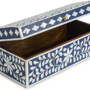 May include: A blue and white wooden box with a floral design inlaid with mother of pearl. The box has a hinged lid with a brass knob.