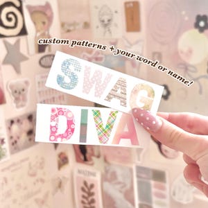 Puede incluir: Dos pegatinas rectangulares con las palabras SWAG y DIVA en letras mayúsculas grandes, negritas y sin remates. Cada letra está rellena con un patrón único, incluyendo cuadrícula azul, lunares rosas, vetas de madera, flores y cuadros.