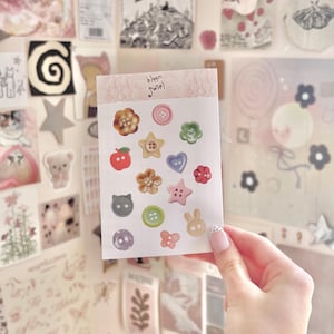 Peut inclure: Une feuille d'autocollants décoratifs avec diverses formes, notamment des fleurs, des étoiles, des cœurs et des boutons. Les autocollants sont de couleurs pastel comme le rose, le vert et le jaune. La feuille porte le texte "bloom swirl" en haut.