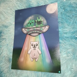 May include: A whimsical art print featuring a white pug standing in front of a rainbow beam of light. Above, two green alien dogs are in a spaceship. The background is a night sky with a full moon.
