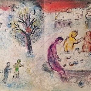 May include: A painting depicting a group of people gathered around a table in a village setting. The scene is painted in a whimsical style with vibrant colors, including pink, yellow, green, and blue. The figures are stylized and have large, expressive eyes. The background features a tree with bare branches and a cluster of houses with snow-covered roofs.