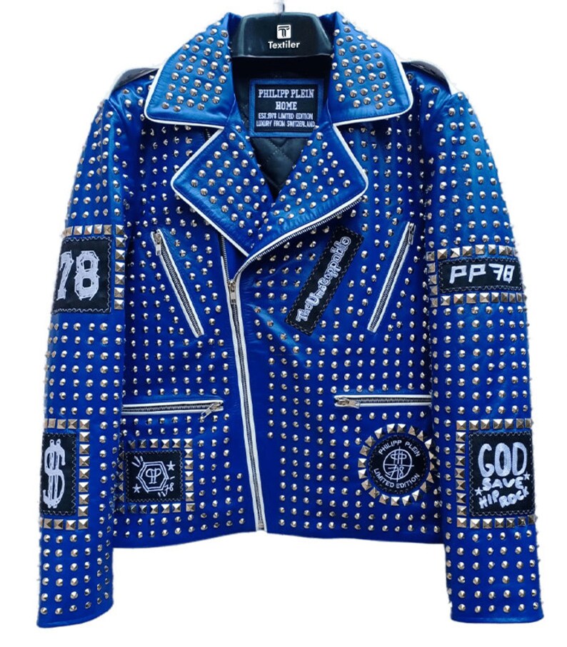 May include: A blue leather jacket with silver studs and various patches. The patches include the text "The Unstoppable", "PP 78", "God Save Hip Rock", and "Philipp Plein Home Limited Edition".