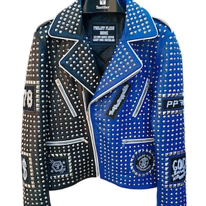 May include: A black and blue leather jacket with silver studs. The jacket has several patches, including "78", "The Unstoppable", "PP 78", "Philipp Plein Home", "God Save Hip Hop", and a dollar sign.