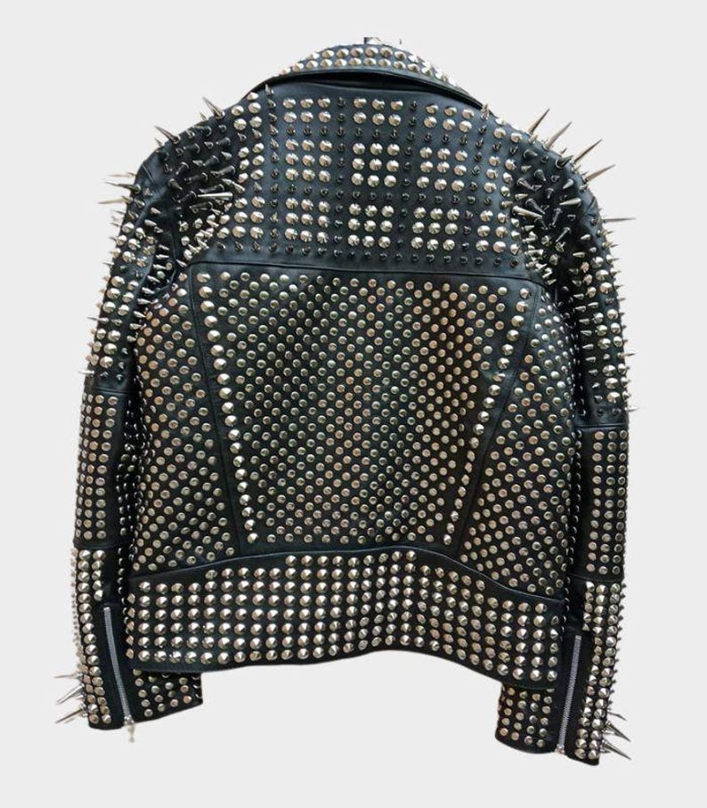May include: Black leather jacket covered in silver studs and spikes. The back of the jacket is visible, showcasing the extensive studding and spiked accents on the shoulders and collar. The jacket has a classic biker style with a zipper closure.