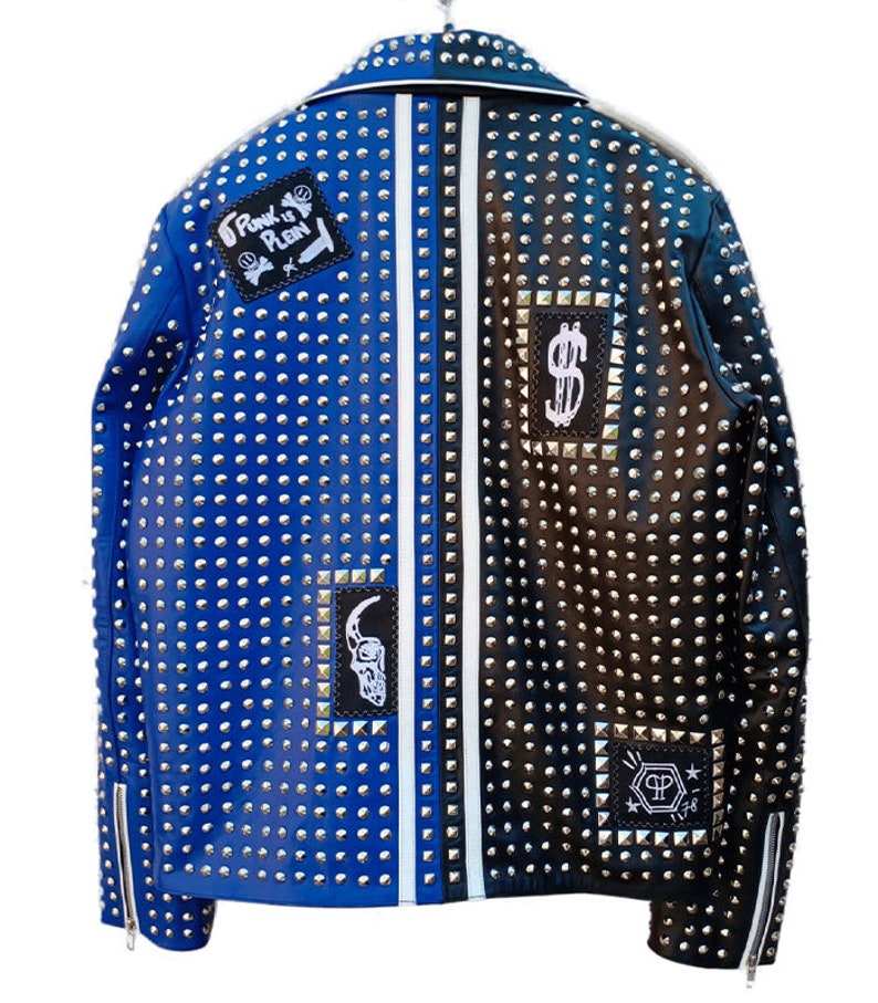 May include: A blue and black leather jacket with silver studs and patches. The jacket has a white stripe down the center back and features patches with the text "Punk is Plan" and a dollar sign.
