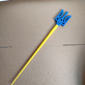 以下が含まれることがあります： 青い三叉のついた黄色の木の棒。三叉はウクライナの象徴です。