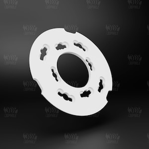 May include: A white plastic ring with a decorative design of multiple cutouts around the outer edge. The ring is slightly angled and appears to be a component for a machine or device.