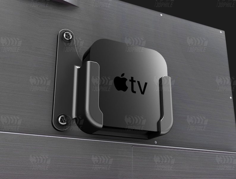 May include: A black Apple TV streaming device mounted on a black metal wall mount. The device has a white Apple logo and the text "tv" on the front.