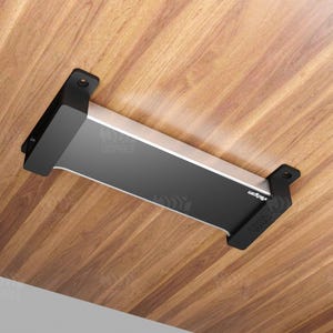 May include: A black and silver rectangular object with the text "zrdgpm" and "3DPHILE" printed on it. The object is mounted on a wooden surface. The object has two black brackets on each end.