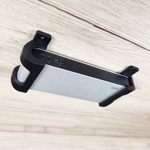 May include: A black and silver device with ports and a label that reads "400000" is mounted to a light wood surface.