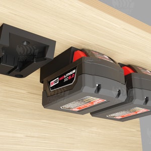May include: Two black and red M18 REDLITHIUM XC 6.0 batteries mounted on a black wall mount. The mount is attached to a wooden surface.
