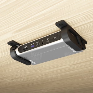 May include: A silver device with black plastic brackets mounted to a wooden surface. The device has multiple ports and the text "SIMPLE" on the front.