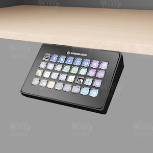 May include: A black Stream Deck with a grid of 32 customizable buttons, each with a different icon. The Stream Deck is mounted on a desk.