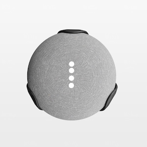 May include: A grey fabric-covered smart speaker with a black mounting bracket. The speaker has four white indicator lights.