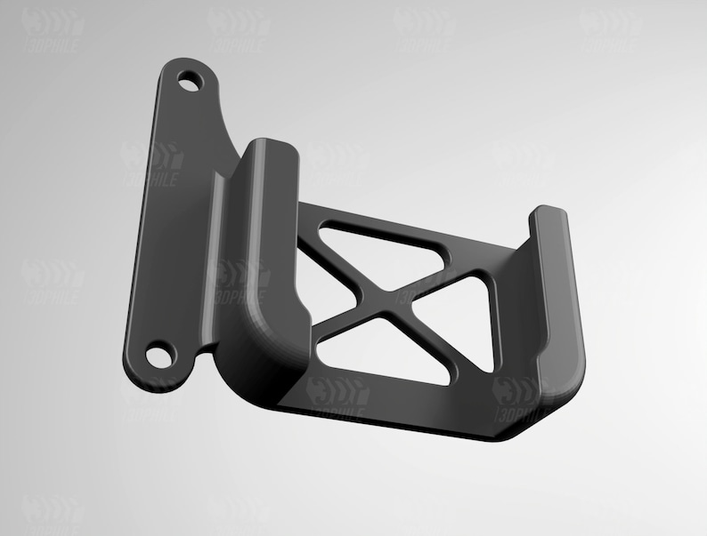 May include: A black plastic phone holder with a geometric design. The holder has a curved back and a flat front with a cutout for a phone.
