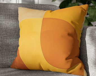 May include: A yellow and orange geometric patterned throw pillow with a modern design.