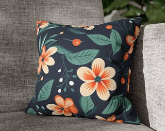 Op de afbeelding: Een donkerblauw kussen met een bloemenpatroon met oranje en witte bloemen, groene bladeren en witte bessen.