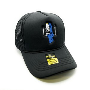 May include: Black trucker hat with a black mesh back. The hat features an embroidered image of a cartoon character with the text "Official Licensed Product" on a yellow tag.