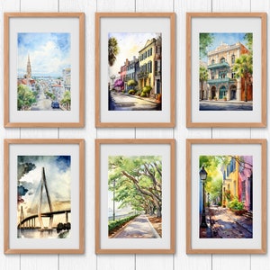 May include: Six framed watercolor paintings of various scenes in Charleston, South Carolina. The paintings depict a street with a church in the distance, a street with colorful houses, a street with a historic building, a bridge over water, a street with trees, and a street with a lamppost.