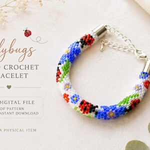 May include: A bead crochet bracelet featuring a pattern of red ladybugs, blue flowers, and green leaves on a white background. The bracelet has silver-toned metal end caps and a lobster claw clasp with an adjustable chain. Text reads Ladybugs.