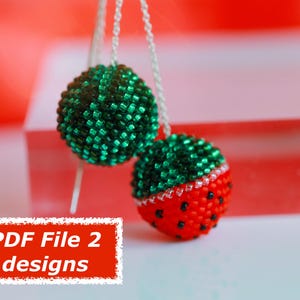 May include: Two beaded ornaments suspended from silver chains. One is green, the other is red with black accents and a green top, resembling a watermelon. The text "PDF File 2 designs" is in a red box.