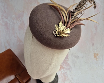 Fascinator aus braun, Filz, Feder, Knopf.