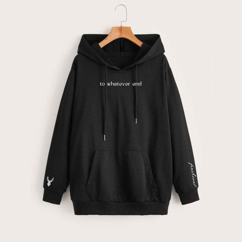 K&ouml;nnte beinhalten: Schwarzer Kapuzenpullover mit einer K&auml;ngurutasche und wei&szlig;em Text, der "to whatever end" lautet. Der linke &Auml;rmel hat ein kleines wei&szlig;es Hirschmotiv und der rechte &Auml;rmel hat das Wort "freeflow" in Wei&szlig;.