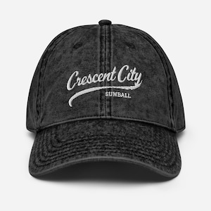 Może przedstawiać: Czarna vintage baseballówka z bawełny, wyprana, z białym haftem z napisem "Crescent City Sunball".