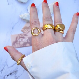 Hand modeling 5 chunky gold rings